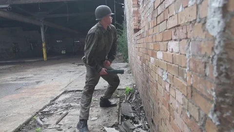 American soldier throws grenade out window then ducks enemy fire Stock Footage 79972942