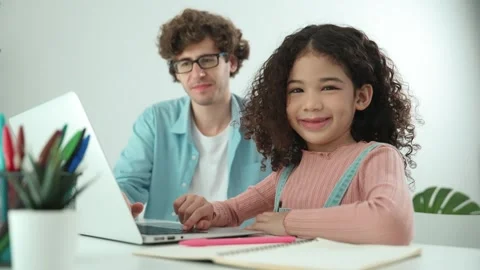 American student looking at camera while working on laptop with dad. Pedagogy. Stock Footage 267039027