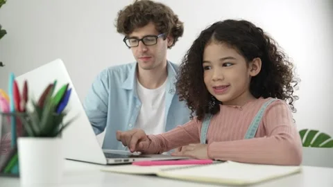 American student looking at camera while working on laptop with dad. Pedagogy. Stock Footage 274742502