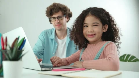 American student looking at camera while working on laptop with dad. Pedagogy. Stock Footage 276228584