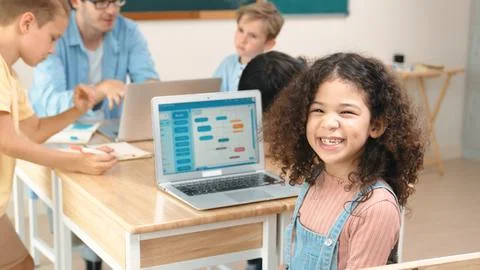 American student looking at camera while learning code in STEM class. Pedagogy. Stock Photos