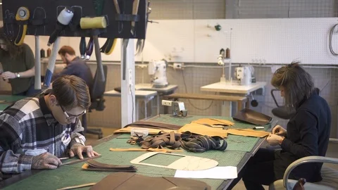 American team of experts work on leather product at desk in lighting room. Stock Footage 120406668