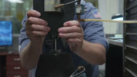American USA Engineer with Flag Patch Uses Machine to Test Durability of Metal Stock Footage 161803256