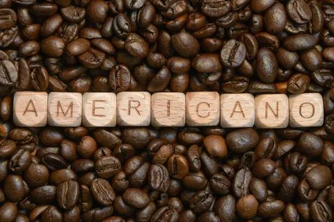 Americano blocks on coffee bean background highlighting coffee culture Stock Photos