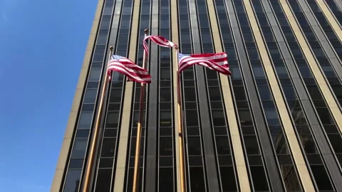 American/USA Flags Wave in Front of Large Office Building Stock Footage 168334148