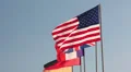 Americas flag is behind all flags on the flagpoles. Waving on blue sky HD Footage