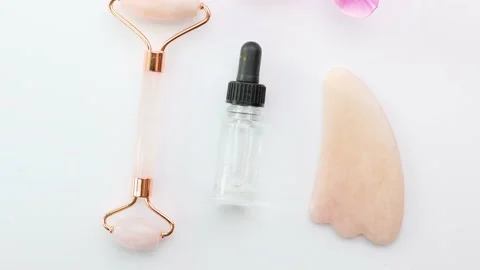 Amethyst and jade roller, flowers and serum in bottle Stock Footage 150227250