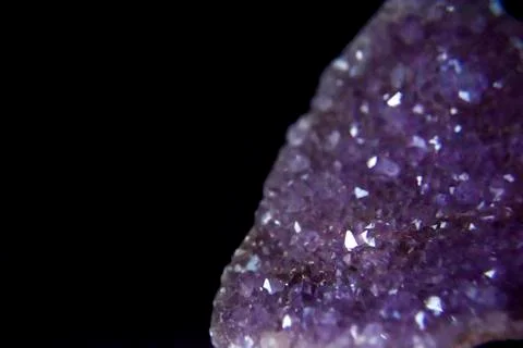 Amethyst crystals on the dark background with the side light. Stock Photos