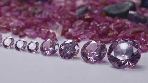Amethyst diamonds in a row on white flore raw ruby gemstone background. Stock Footage 168481480