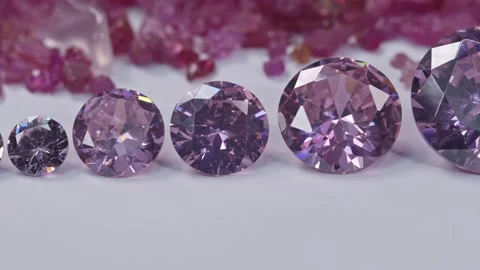Amethyst diamonds in a row on white flore raw ruby gemstone background. Stock Footage 168481620