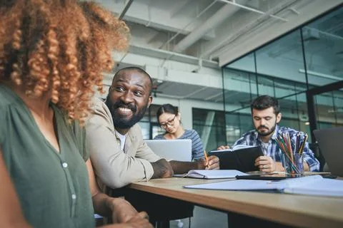Amicable man smiling at young lady at conference meeting Stock Photos