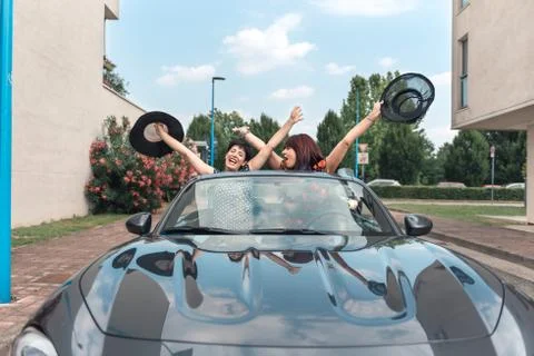 Amiche donne alla guida di un'auto convertibile godendo le vacanze divertendo Stock Photos