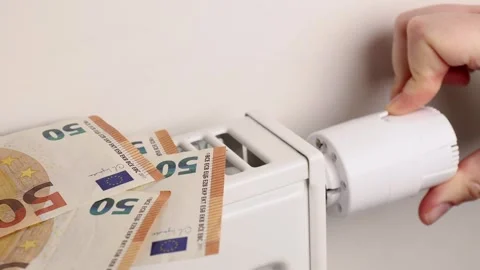 Amid escalating heating expenses, a hand turns the thermostat Stock Footage 280640502
