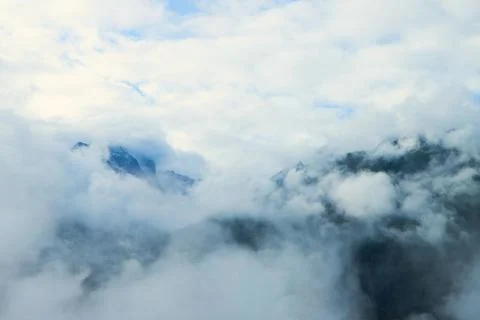 Amidst the Clouds: Alpine Peaks Dancing with the Sky Stock Photos