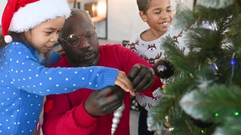Amily - dad and two small children in santa hats smile and decorate the Stock Footage 221415028