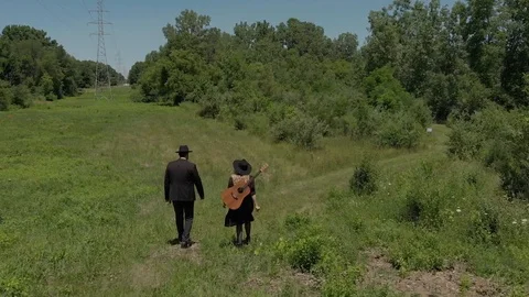 Amish artists walking on green path Stock Footage 124938965
