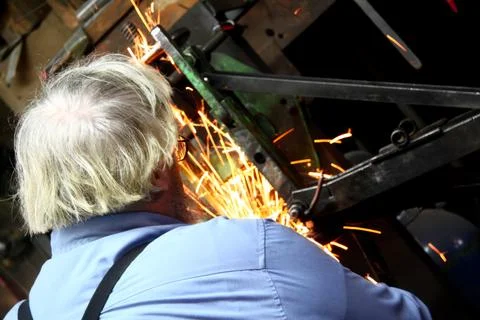 Amish Man Working with a Sparking Machine in a Workshop Stock Photos