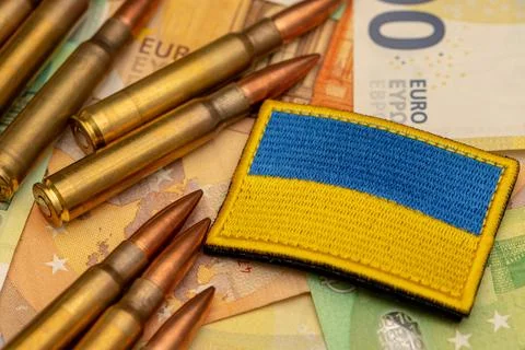 Ammunition and Ukraine flag patch placed on euro banknotes as defense spend.. Fotos de archivo
