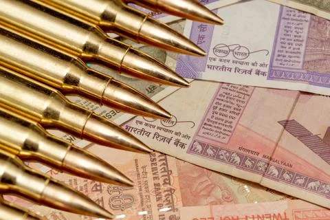 Ammunition in the background of Indian currency notes illustrates the conce.. Fotos de archivo