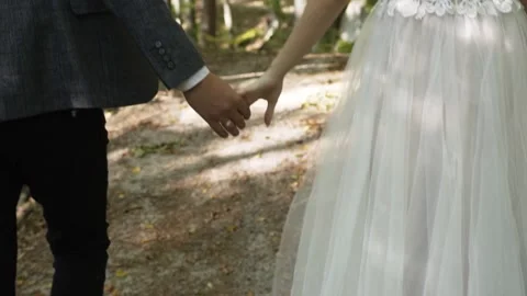 Among forest guy walks by handle with girl, on the guy's hand an engagement ring Vidéo 140276186
