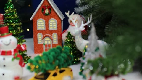 Among the green trees there is an orange house with Santa Claus and a snowman Stock Footage 336971540