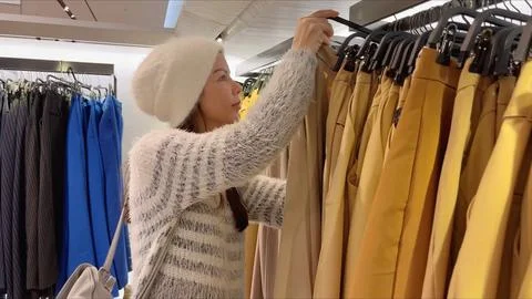 Among a large selection of clothes, hang on hangers on a rack-hanger, correctly Stock Photos