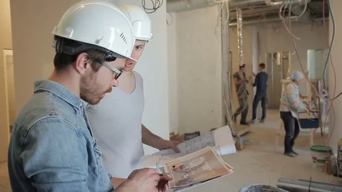 Among the repairs, two men in helmets discuss a project on securities. Video stock 78158882