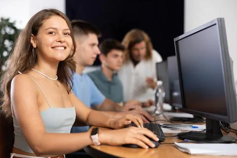 Among students of computer academy programmers, young girl is sitting and Stock-Fotos