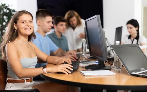 Among students of computer academy programmers, young girl is sitting and Stock-Fotos