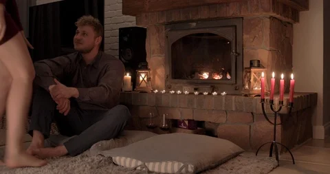 Amorous young couple share a romantic kiss in front of the fireplace Vidéo 104640036