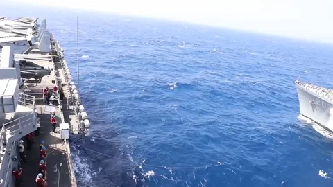 The amphibious assault ship USS Bataan (LHD 5) conducts a replenishment-at-sea Stock Footage 75833924