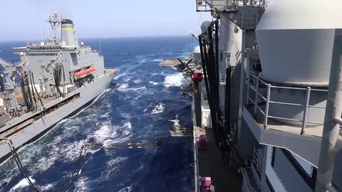 The amphibious assault ship USS Bataan (LHD 5) conducts a replenishment-at-sea Stock Footage 75834246