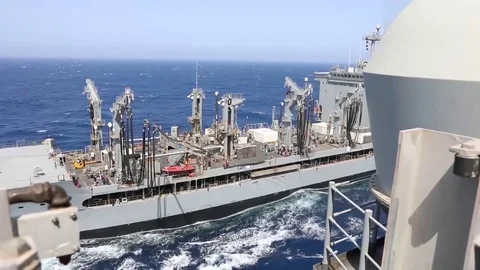 The amphibious assault ship USS Bataan (LHD 5) conducts a replenishment-at-sea Stock Footage 75834348