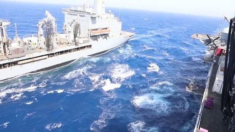 The amphibious assault ship USS Bataan (LHD 5) conducts a replenishment-at-sea Stock Footage 75834485