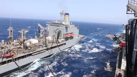 The amphibious assault ship USS Bataan (LHD 5) conducts a replenishment-at-sea Stock Footage 75834517