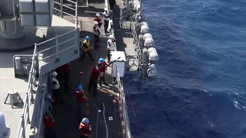 The amphibious assault ship USS Bataan (LHD 5) conducts a replenishment-at-sea Stock Footage 75835605