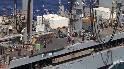The amphibious assault ship USS Bataan (LHD 5) conducts a replenishment-at-sea Stock Footage 75835644