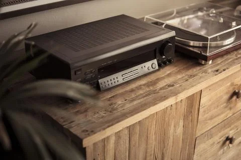 Amplifier and vinyl record player on a wooden sideboard Stock Photos