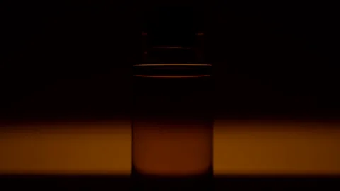 An ampoule with a cure for covid 19 stands on yellow background on the table Video stock 164639853