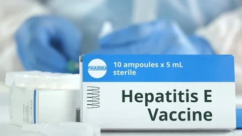 Ampoules with hepatitis E vaccine on the table near working laboratory assistant Stock Footage 126879752