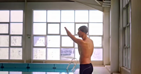 Amputee professional athlete doing arms stretches in indoor pool 스톡 동영상 146143119