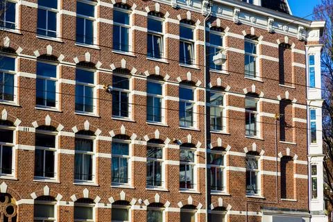 Amsterdam Brick Building Facade With Repeating Window Pattern Stock Photos