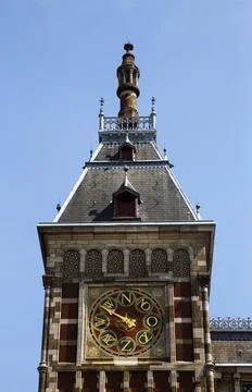 Amsterdam Centraal station clock tower against clear blue sky, Netherlands Фото