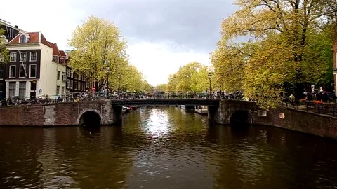 Amsterdam, The Netherlands, bridge on canal , Holland. People walking. Spring. Stock Footage