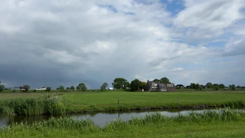 Amsterdan Forest, serene open field with water body and sky, aerial view of Stock Footage 342752238