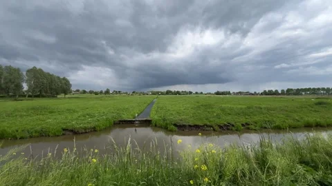 Amsterdan Forest, Storm clouds over rural drainage canal with concrete sluice Stock Footage 342755192