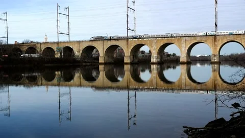 Amtrak Acela express train races across an arch bridge in New Jersey Stock Footage 234660504