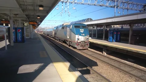 Amtrak deisel engine pulls two cars into station, stock footage Stock Footage 303943973