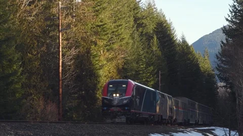 Amtrak Empire Builder passenger train in winter in Washington Cascades Stock Footage 280501040