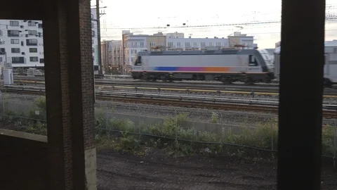 Amtrak Train Passing by Abandoned Building Stock Footage 121289503
